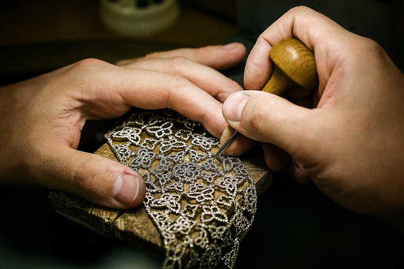 A craftsman sets diamonds into an intricate jewel in Alexander Arne's workshop.