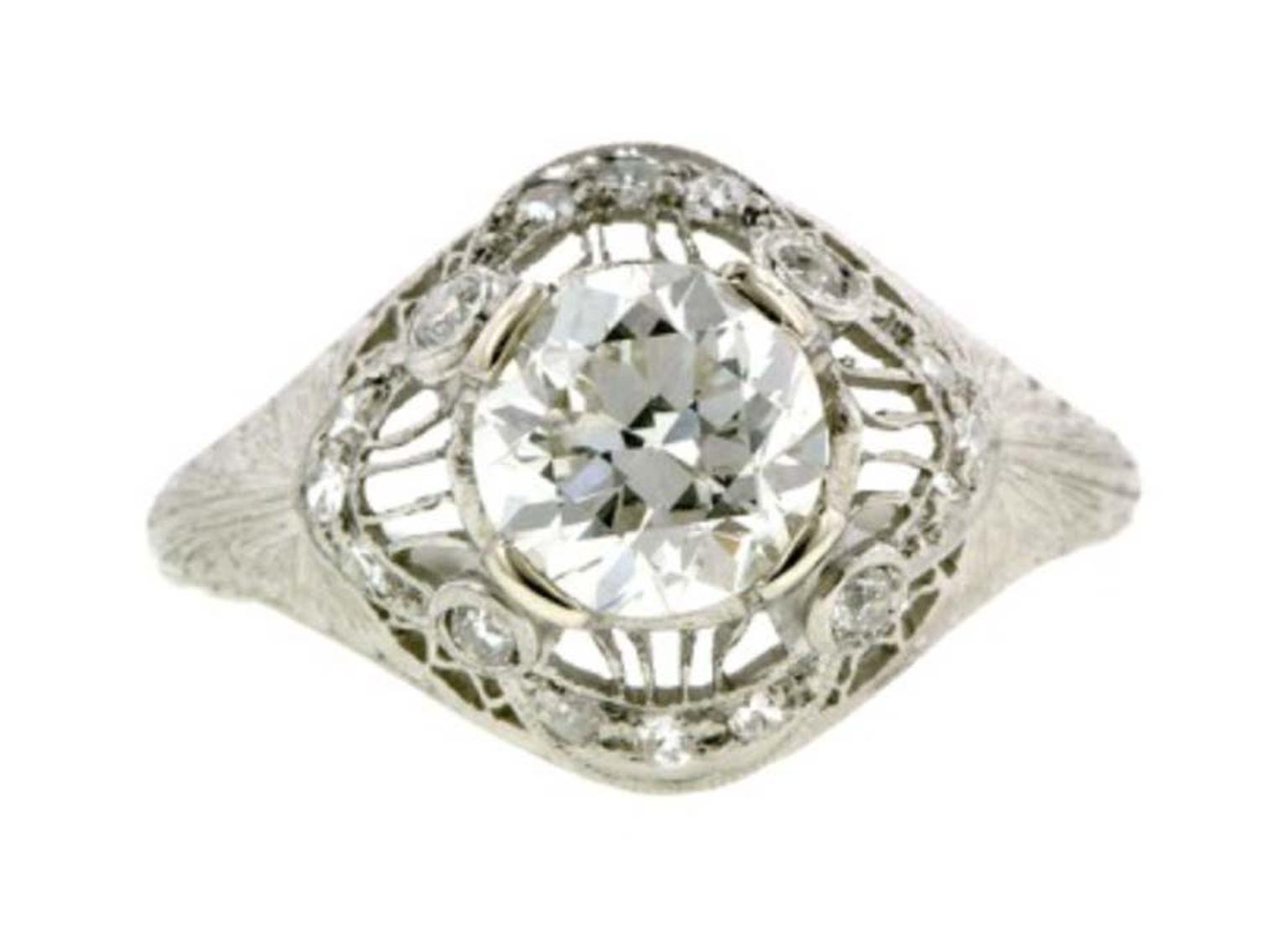 This Edwardian engagement ring circa 1915, available at Doyle & Doyle, centres an old European-cut diamond, additionally set with 12 single-cut diamonds, and four old European-cut diamonds, in an ornate, filigree and swag design with engraved shoulders, f
