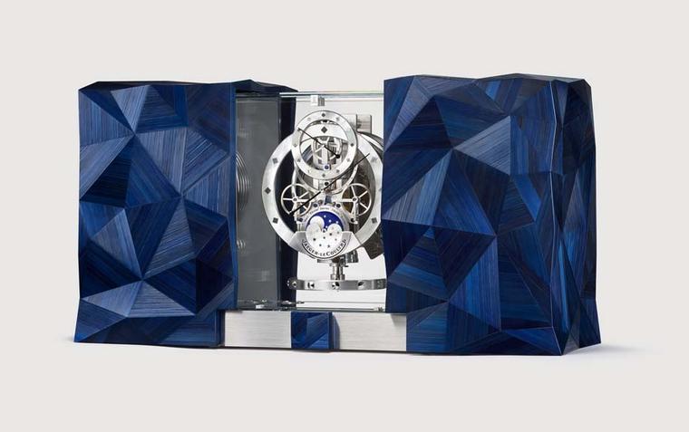 Jaeger-LeCoultre celebrates the cosmos with the Atmos Marqueterie Paille table clock. The  wooden cabinets at either side of the clock feature pyramid-shaped structures made from blue-tinted straw marquetry. By sliding open the doors, the Atmos clock, whi