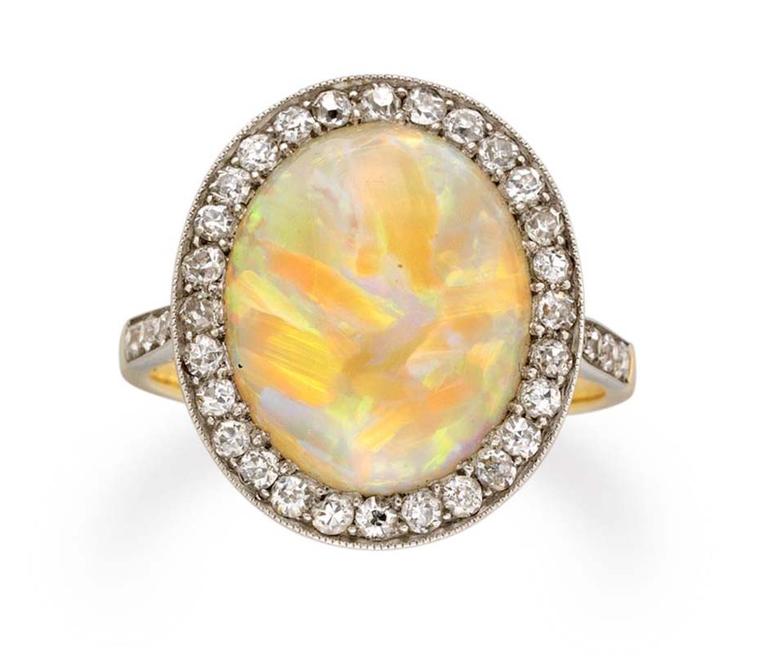 This Edwardian opal and diamond cluster ring circa 1910, available at Bentley & Skinner, has an oval cabochon opal set in the centre of an eight-cut, diamond-set surround, millegrain-set, with diamond-set shoulders.