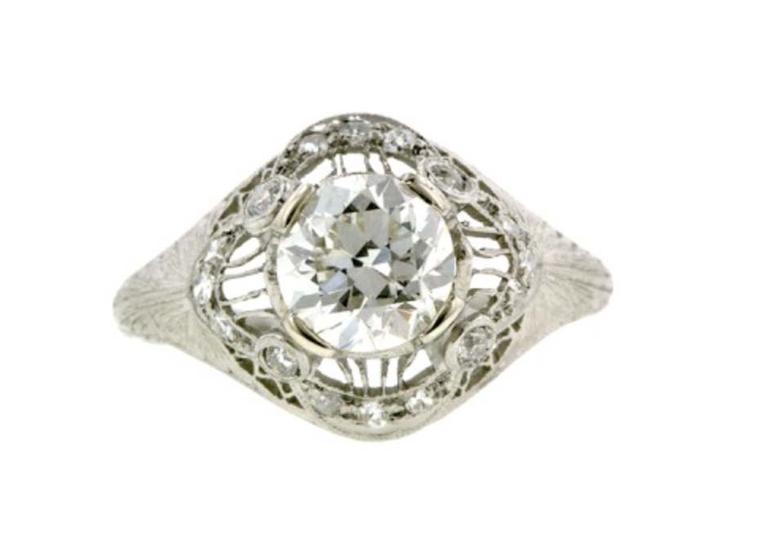 This Edwardian engagement ring circa 1915, available at Doyle & Doyle, centres an old European-cut diamond, additionally set with 12 single-cut diamonds, and four old European-cut diamonds, in an ornate, filigree and swag design with engraved shoulders, f