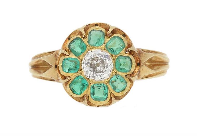 Emerald and diamond cluster Victorian engagement ring with a central cushion-shape, old-cut diamond encircled by a single row of square emerald-cut natural emeralds, dating from around 1880, from Berganza.