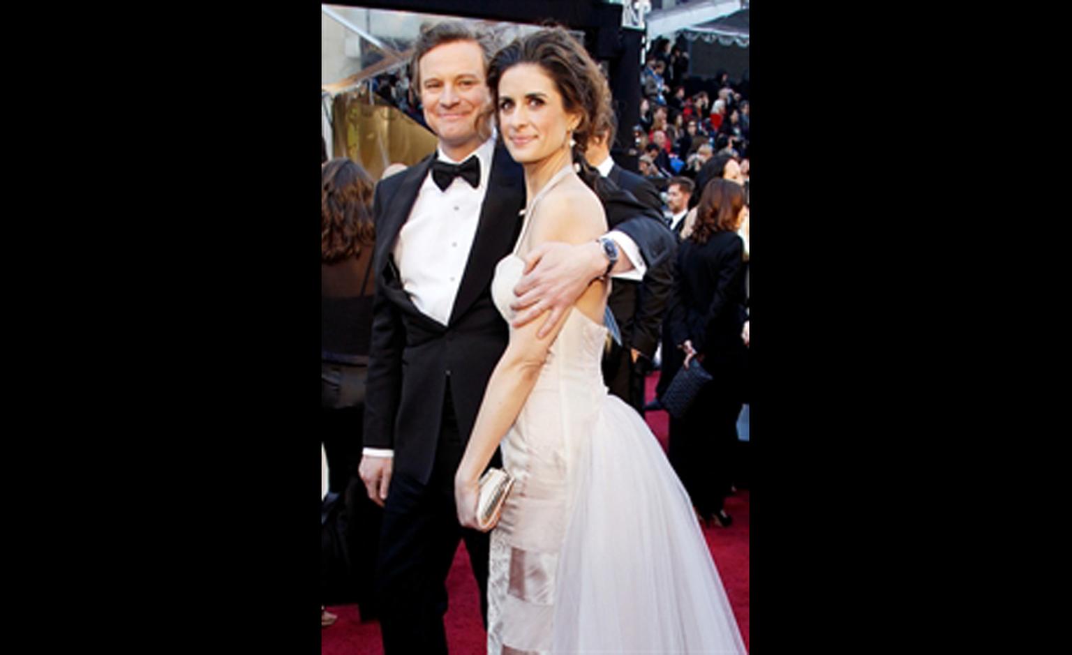 Colin Firth with a Chopard on his wrist and his wife Livia Giuggioli tucked under his arm at the Oscars 2011