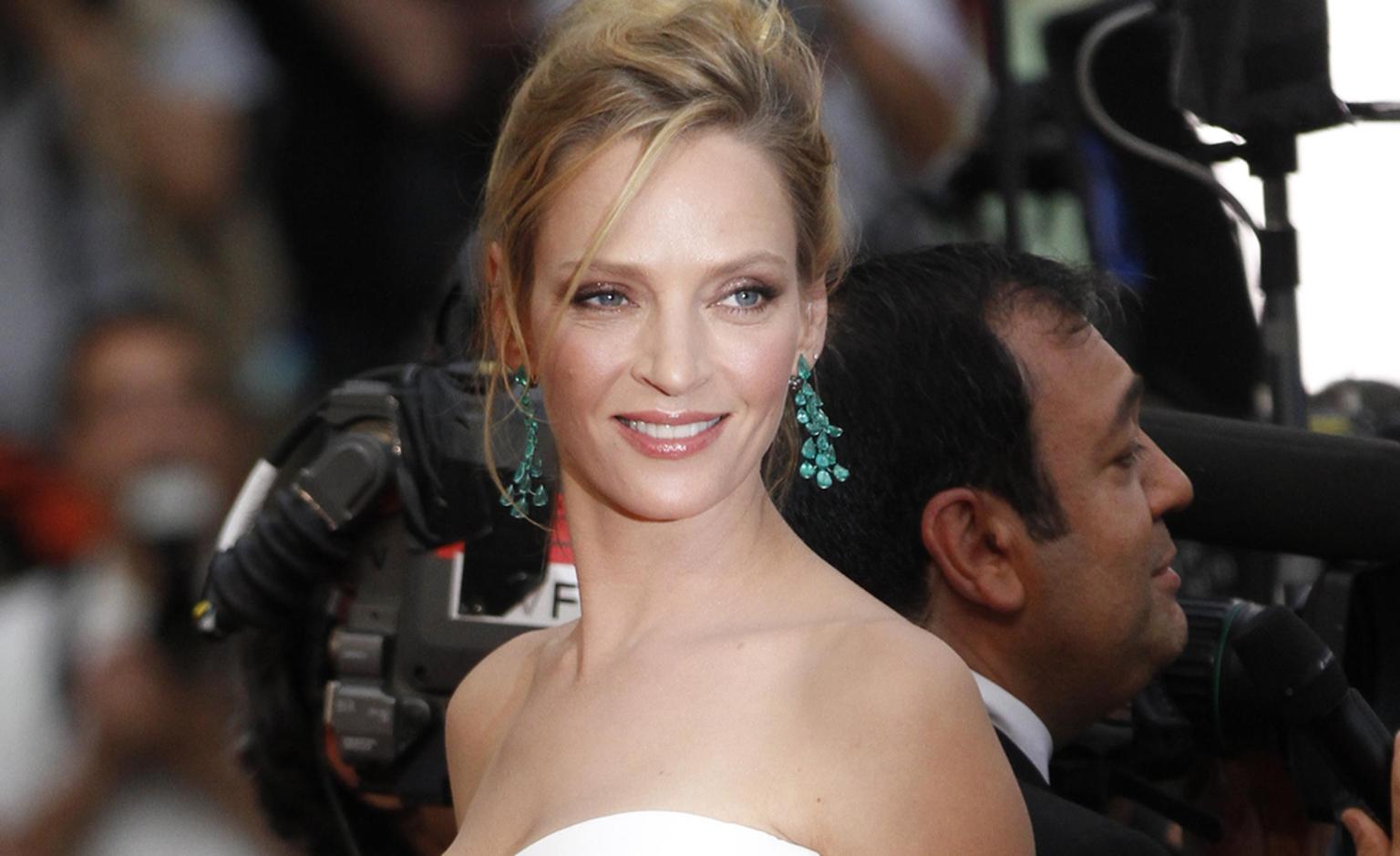 Uma Thurman in Chopard emerald chandelier earrings and bracelet at Cannes Film Festival 2011. The earrings sparkle with 34 pear-shaped emeralds.