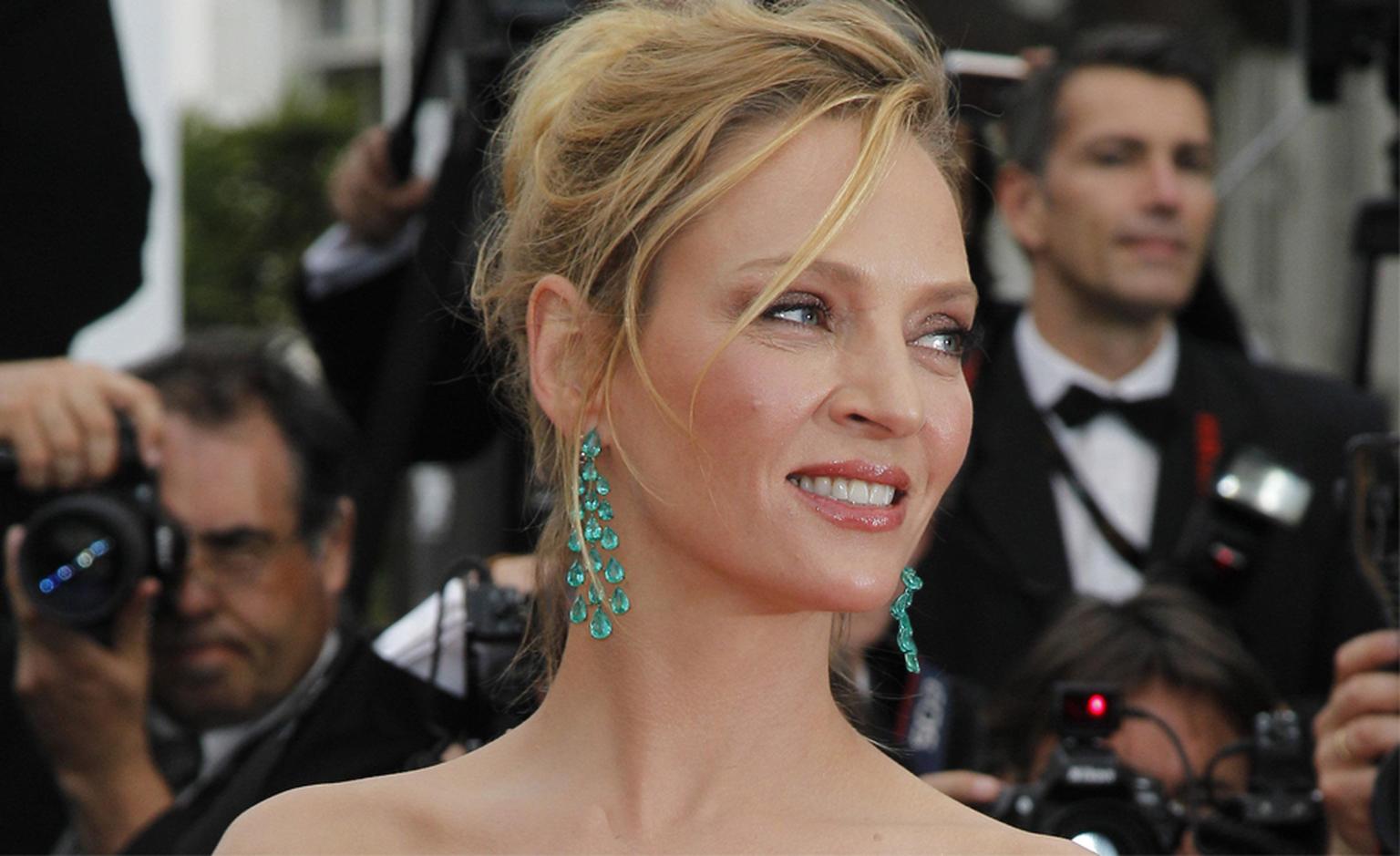 Uma Thurman in Chopard emerald chandelier earrings and bracelet.