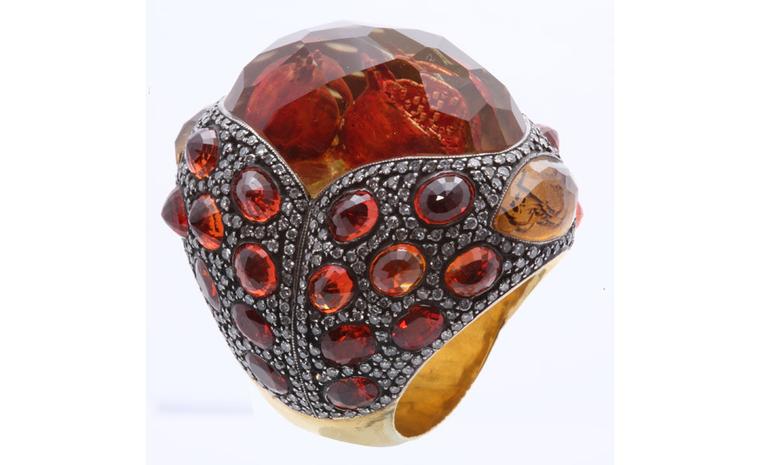 Sevan Biçakçi Pomegranate ring. The pomegranates are carved into the back of a precious stone that is mounted into the outsized ring set with diamonds.