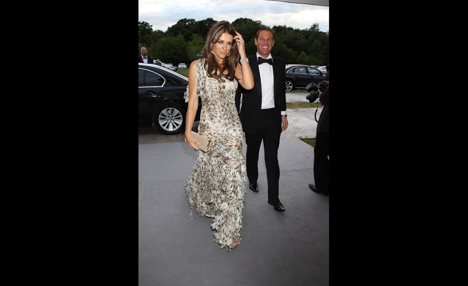 Elizabeth Hurley makes a grand entrance in Chopard diamond earrings and bracelet and a Cavalli gown with beau Shane Warne a discreet few steps behind.