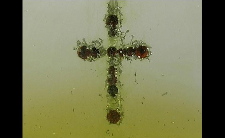 Gisbert Stach. Transformation cross pendant in silver with garnets in acid still image.