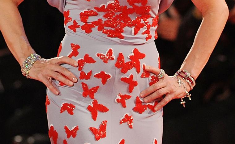 Close up of Madonna's wrists on the red carpet at the Venice Film Festival 2011 wearing three vintage Cartier diamond bracelets as well as a replica of Wallis Simpson's diamond cross bracelet and a Cartier diamond panther ring.
